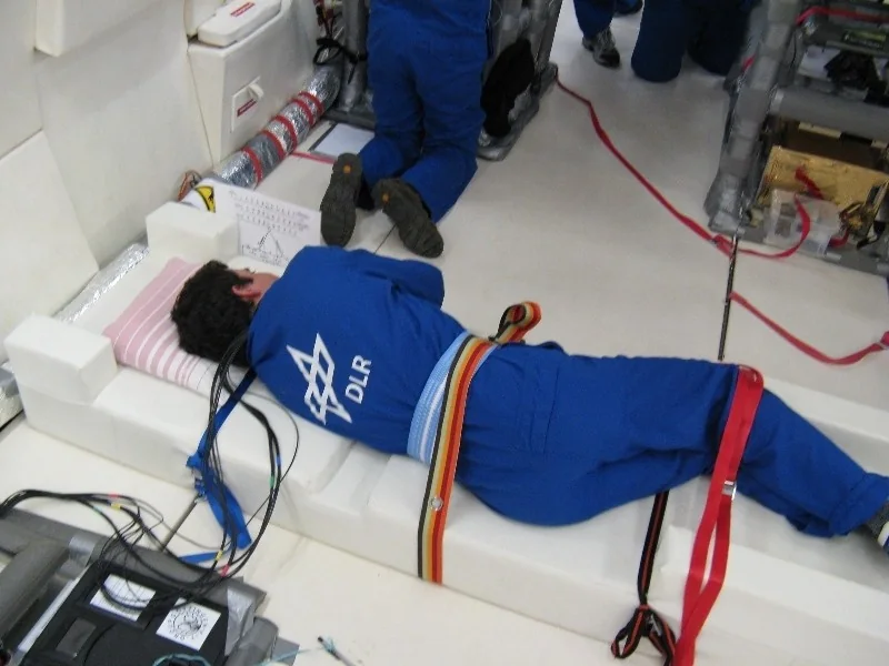 Participant secured on padded experimental couch with electrode and instrumentation cables